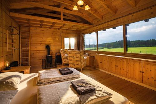 a bedroom with two beds in a log cabin at Vyhlídkový srub na kraji Brd in Hŭrky
