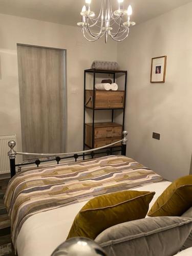 a bedroom with a bed and a chandelier at Mumbles - Modern Apartment with panoramic sea views in Oystermouth