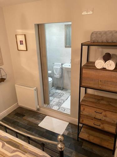 a bathroom with a mirror and a sink and a toilet at Mumbles - Modern Apartment with panoramic sea views in Oystermouth