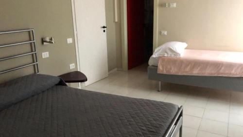 a bedroom with two beds and a door to a room at hotel garni Santa Caterina in Orta San Giulio