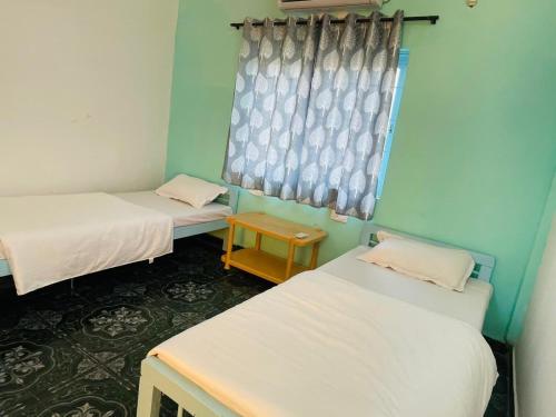 a room with two beds and a window at Trippy Spot Hostel & Cafe in Vagator