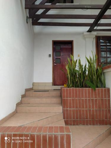 a building with stairs and a wooden door at Conjunto vacacional Cocomar-Casa 6-4h in Carrizal