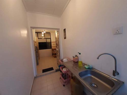 a kitchen with a stainless steel sink and a hallway at Holiday Villa Famosa in Melaka