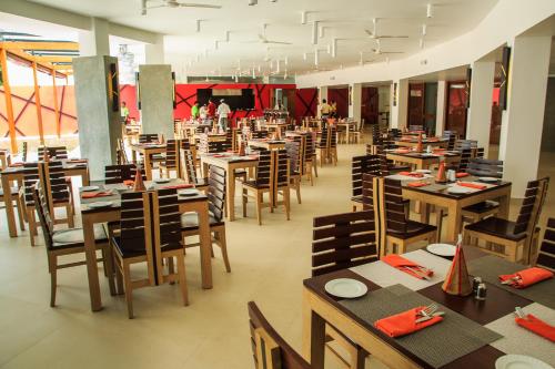 a restaurant with tables and chairs and people in the background at Camelot Beach Hotel in Negombo
