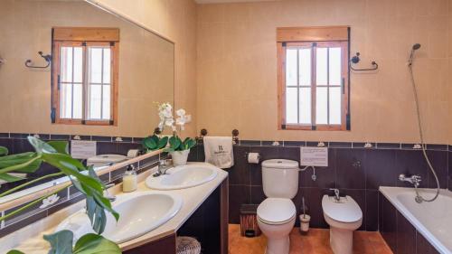 bagno con 2 lavandini, servizi igienici e specchio di Casa Villalba Almachar by Ruralidays ad Almáchar