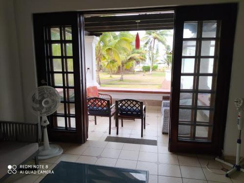 an open door to a patio with chairs and a fan at Conjunto vacacional Cocomar-Casa 6-4h in Carrizal