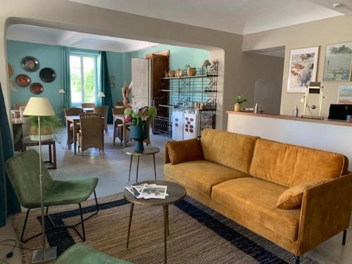 un salon avec un canapé et une cuisine dans l'établissement Hôtel de Mirmande, à Mirmande