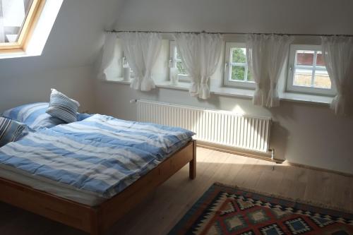 a bedroom with a bed and two windows at Wohnen am Dehnthof Haus 2 in Kappeln