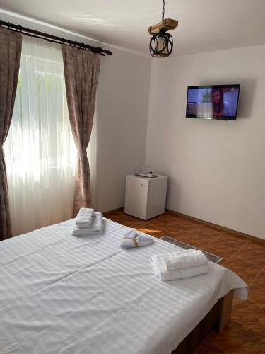 Un dormitorio con una cama blanca con dos toallas encima. en Casa Amos, en Costinesti