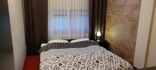 a bedroom with a bed and a window with a curtain at Hotel Graal Targowisko in Targowisko