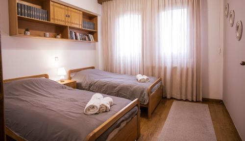 2 Betten in einem kleinen Zimmer mit Handtüchern darauf in der Unterkunft Georgia's GuestHouse in Kastoria