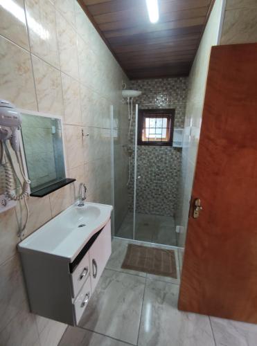 W łazience znajduje się umywalka i prysznic. w obiekcie CHALES CARVALHOS w mieście Monte Verde