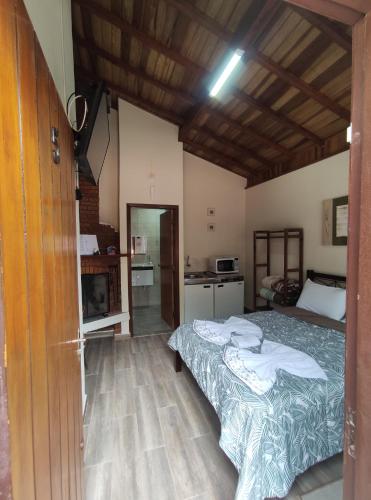 sypialnia z 2 łóżkami i kuchnią w obiekcie CHALES CARVALHOS w mieście Monte Verde