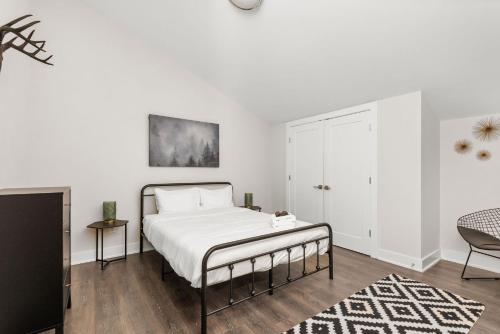 a white bedroom with a bed and a tv at Mason Lofts at West End in Nashville