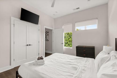 a white bedroom with a bed and a window at Mason Lofts at West End in Nashville