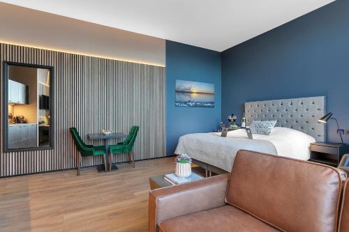 ein Schlafzimmer mit einem Bett, einem Sofa und einem Tisch in der Unterkunft Alva Hotel in Reykjavík