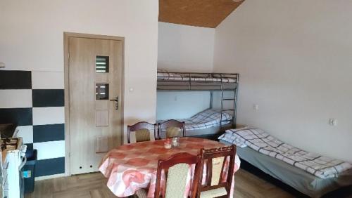 a room with a table and two bunk beds at Noclegi u Dorki in Kurzętnik