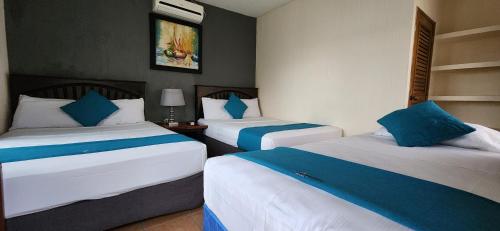 1 Schlafzimmer mit 2 Betten in Blau und Weiß in der Unterkunft Hotel Real del Rio in Rio Dulce