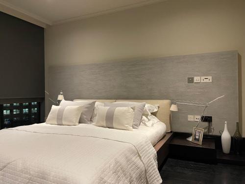 1 dormitorio con 1 cama grande con almohadas blancas en Hi-End 2BR, 2BR Apt, Heart of Canary Wharf, en Londres