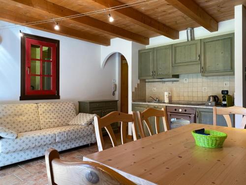 una cucina e un soggiorno con tavolo e divano di Panorama Sozzine a Ponte di Legno