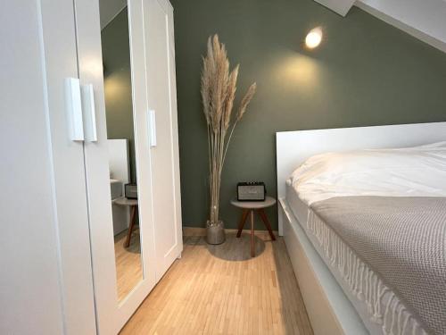 1 dormitorio con 1 cama y un jarrón con una planta en Helles Apartment im Zentrum en Graz