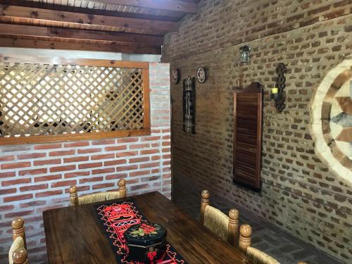 uma mesa de madeira num quarto com uma parede de tijolos em Casa Quinta Chascomús em Chascomús