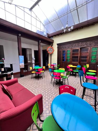 a room with tables and colorful tables and chairs at Prisma Hostel in Bogotá