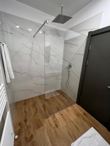 a bathroom with a shower with a glass door at HELIOS Boutique Hotel in Săcele