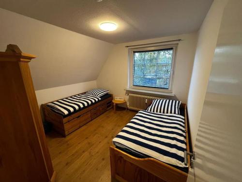 two beds in a room with a window at Schöne Wohnung an der Nordsee in Mildstedt in Mildstedt