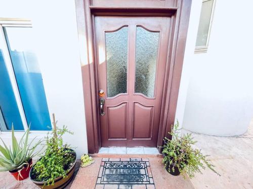 une porte rouge sur une maison avec des plantes en pot dans l'établissement Casa cerca del mar! 4 Habitaciones con aire acondicionado, à Puerto Vallarta