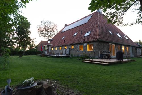 a large brick house with a green yard at Vakantiehuis met fraai uitzicht in Echten