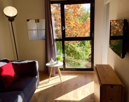 a living room with a couch and a large window at Ma place au sud Aix Parking in Aix-en-Provence