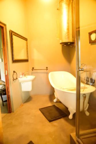 a bathroom with a bath tub and a sink at Kruger Ranch in Magaliesburg