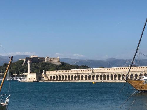 a large stone bridge over water with a castle in the background at Vieil Antibes, ravissant 2p avec petite terrasse in Antibes