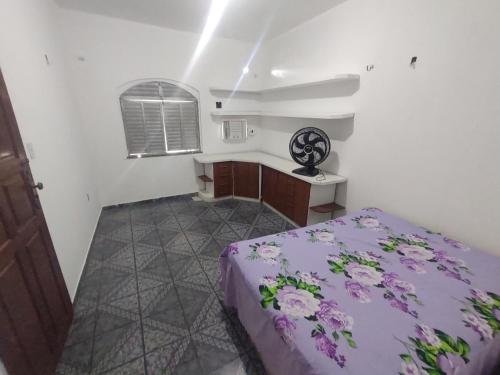 a bedroom with a purple bed and a desk at Casa grande em área central, bem iluminada e vent. in Manaus