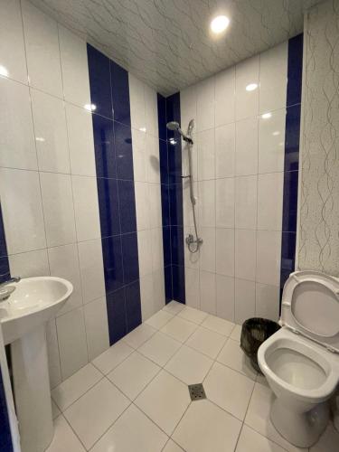 a bathroom with a shower and a toilet and a sink at Liga Hotel and Restaurant in Shinuhayr