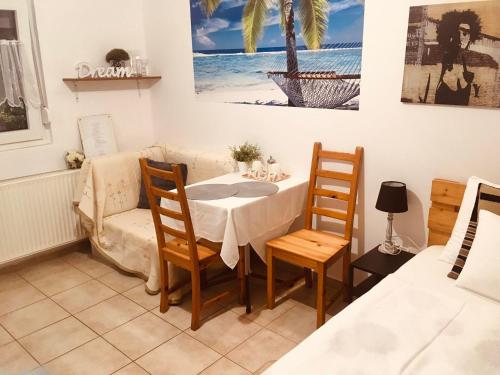 Katica Apartmanok في إيغيرسولوك: غرفة طعام مع طاولة وكراسي وأريكة