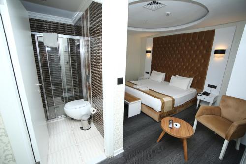 アンカラにあるGrand Silay Hotelのベッドとバスルーム付きのホテルルームです。