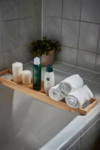 a wooden shelf with towels and candles on a bath tub at Cosima, mit Liebe zum Stil. in Kaiserslautern