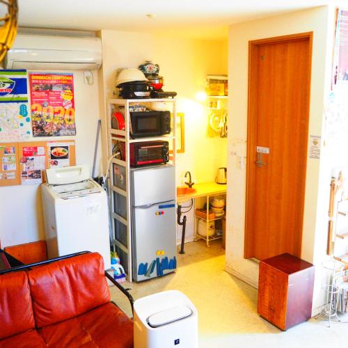 a living room with a microwave and a refrigerator at Tokushima GuestHouse【uchincu】 in Tokushima