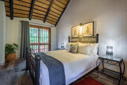 a bedroom with a large bed and a window at Kruger Park Lodge Unit No. 221 in Hazyview