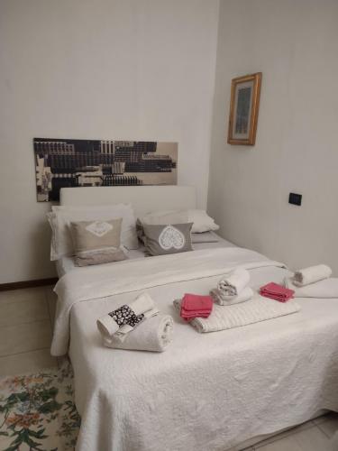 a white bed with towels and shoes on it at Casa Anida in Bergamo
