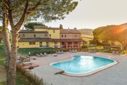 a large swimming pool in front of a house at Casa d'Era Country Holiday Houses in Lajatico