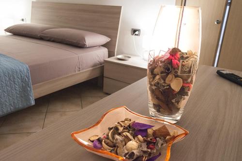a table with a glass vase filled with shells on it at Chiara's Home in Brindisi