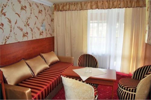 a room with a couch and a table with chairs at Przystań Caryńska w Polańczyku in Polańczyk