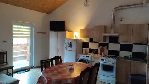 eine Küche mit einem Tisch und einem weißen Kühlschrank in der Unterkunft Noclegi u Dorota in Kurzętnik