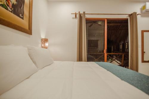 a white bed in a room with a window at Aldea San Lam - Oasis Of Tulum in Tulum