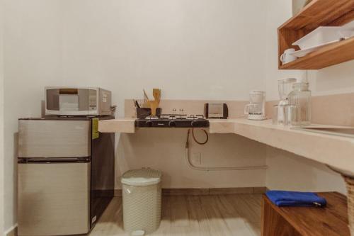 a kitchen with a refrigerator and a microwave on a counter at Aldea San Lam - Oasis Of Tulum in Tulum