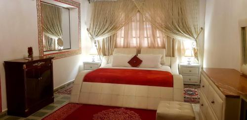 1 dormitorio con 1 cama y una ventana con cortinas en Riad Jasmine Sud, en Zagora