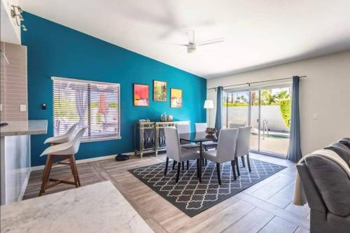 a dining room with blue walls and a table and chairs at Fiesta Escuela in Palm Springs